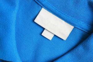 em branco branco lavanderia Cuidado roupas rótulo em azul camisa tecido textura fundo foto