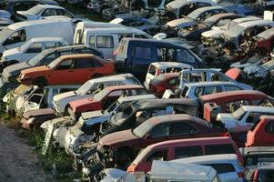 uma ampla pilha do carros dentro uma ferro-velho foto