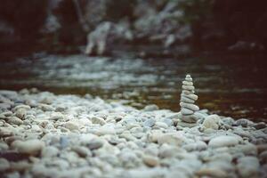 pirâmide do pedras em a rio banco. zen zen conceito. foto