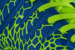 fragmento do uma azul tênis com verde atacadores fechar acima. tênis textura foto