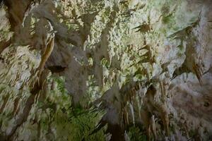 a caverna é cársico, surpreendente Visão do estalactites e estalagnites iluminado de brilhante luz, uma lindo natural atração dentro uma turista lugar. foto