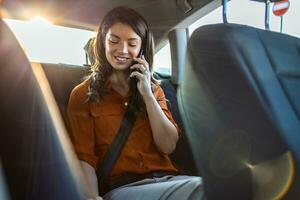 bem sucedido jovem empresária dentro escritório roupas trabalhando usando inteligente telefone dentro sentado costas assento do carro dentro urbano moderno cidade dentro noite. pessoas ocupacional esgotamento síndrome conceito. foto