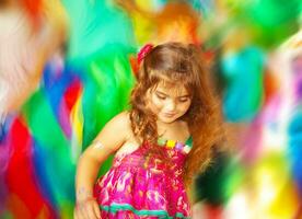 adorável pequeno menina dançando sobre borrão cores fundo foto