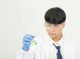 retrato ásia homem aluna cientista ou médico Veja mão segurando reagente mistura laboratório dentro Ciência pesquisa laboratório com teste tubos do vários Tamanho dentro laboratório química laboratório branco fundo foto