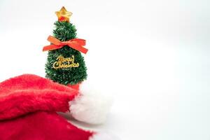 pequeno Natal árvore e santa claus vermelho chapéu isolado em branco fundo. Natal fundo. foto