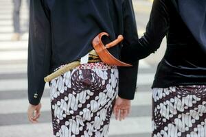 dois mulheres dentro tradicional roupas caminhando baixa a rua foto