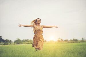 mulher feliz correndo e aproveitando no campo de grama foto