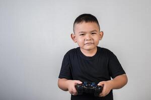 menino feliz jogando computador com um controlador em estúdio foto