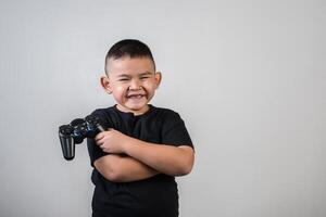 menino feliz jogando computador com um controlador em estúdio foto