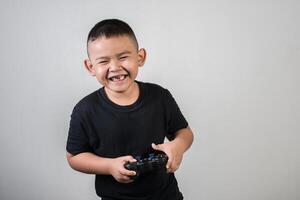 menino feliz jogando computador com um controlador em estúdio foto