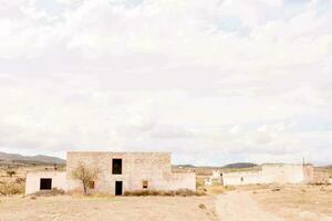 a velho casa dentro a deserto com uma azul céu foto