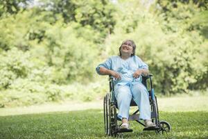 idosa solitária sentada em uma cadeira de rodas no jardim de um hospital foto