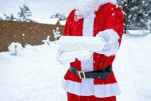 recipientes de serviço de entrega de comida nas mãos do papai noel ao ar livre na neve. promoção de véspera de natal. pedido quente pronto, caixa plástica descartável. catering de férias de ano novo. copie o espaço, simular foto