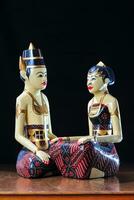 loro loiro ou tradicional javanese Casamento bonecas sentar juntos em a altar com Preto fundo foto