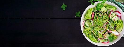 saudável vegano Comida. vegetariano vegetal salada do rabanete, pepinos, alface e vermelho cebola. topo visualizar, bandeira, cópia de espaço foto
