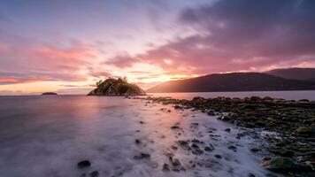 uma grandes exposição foto do uma rochoso litoral às pôr do sol