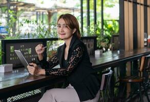 empresária segurando tábua e lápis trabalhando sentado às a cafeteria lado de fora esperando cliente encontro planejamento projeto Gerente financeiro contabilidade, o negócio gestão conceito. foto