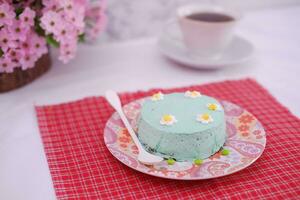 verde chá mousse bolo com copo do café em a mesa. foto