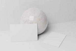 Maquete de papel cartão de visita branco inclinado sobre esfera de mármore foto