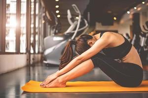 mulher fazendo ioga de flexão e voltada para baixo no fitness foto