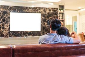 casais asiáticos assistindo televisão com tela em branco foto