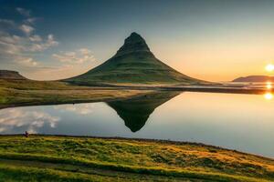 vulcânico kirkjufell montanha com lago reflexão e viajante homem em pé durante nascer do sol às Islândia foto