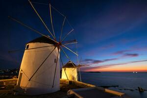 moinhos de vento gregos tradicionais na ilha de mykonos ao nascer do sol, cyclades, grécia foto