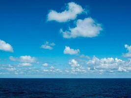 uma azul céu com nuvens sobre a oceano foto