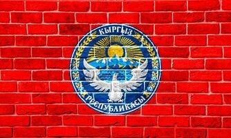 bandeira e casaco do braços do quirguiz república em uma texturizado fundo. conceito colagem. foto