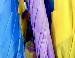 vibrante azul, roxo, e amarelo fechadas guarda-chuva lista dentro loja isolado em horizontal fotografia Razão foto