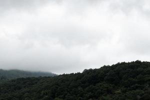 paisagem de montanha verde sob céu nublado em dia chuvoso foto