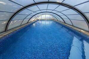 cenário do uma natação piscina com uma fechadas semicircular cobrir fez do metal e vidro foto