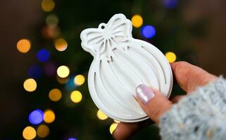 uma garotas mão detém uma faça você mesmo Natal árvore brinquedo fez do gesso. Natal árvore decoração. fechar-se. seletivo foco. foto