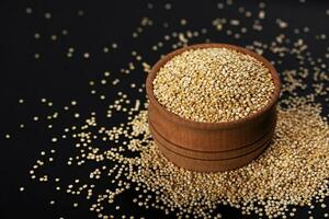 Quinoa sementes. tigela do saudável branco Quinoa grãos em Preto fundo, fechar-se foto