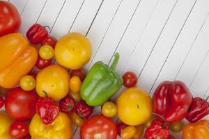 colorida legumes em branco de madeira fundo tomates e páprica, topo Visão foto