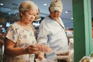 tailandês família mercado dia, compras experimentando local cultura foto