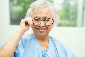 ásia Senior mulher vestindo Óculos ou visão óculos às casa Cuidado serviço. foto