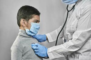 médico examinando pré escola criança foto