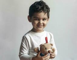 5 anos adorável pequeno criança Garoto jogando com pelúcia Urso brinquedo foto