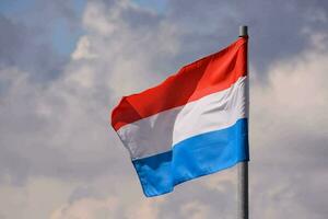 a Países Baixos bandeira é vôo Alto dentro a céu foto