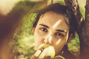 maçã mulher. retrato do lindo Oriente médio mulher às maçã jardim. jovem fêmea posando às a natureza com recentemente escolhido outono maçã frutas. maçã mulher foto