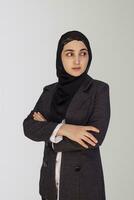 lindo muçulmano empresária dentro hijab contra branco fundo. retrato do bonita Oriente médio fêmea vestindo tradicional islâmico vestir e rigoroso escritório terno foto