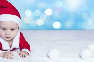 pequeno papai noel. 6-9 meses velho bebê Garoto dentro santa claus fantasia. alegre Natal foto