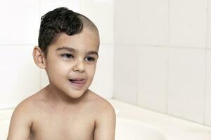 seis anos Garoto às corte de cabelo às lar. pai cortar metade do a filhos cabelo fora às a banheiro foto