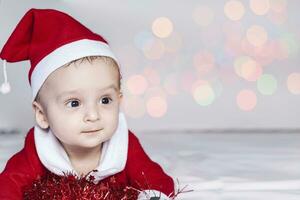 pequeno papai noel. 6-9 meses velho bebê Garoto dentro santa claus fantasia. alegre Natal foto