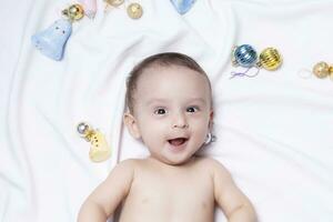 bebê Garoto jogando com Natal bolas e brinquedos foto