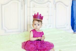 primeiro aniversário. pequeno alegre bebê menina com coroa a comemorar dela primeiro aniversário festa foto