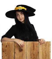 dia das Bruxas menina dentro bruxa traje em de madeira borda foto