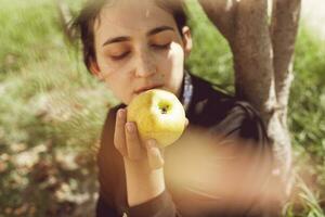 maçã mulher. retrato do lindo Oriente médio mulher às maçã jardim. jovem fêmea posando às a natureza com recentemente escolhido outono maçã frutas. maçã mulher foto