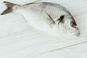 mar fresco dorado peixe mentiras em uma branco mesa foto